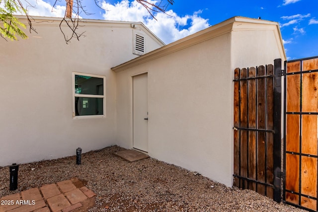 view of home's exterior featuring stucco siding and fence