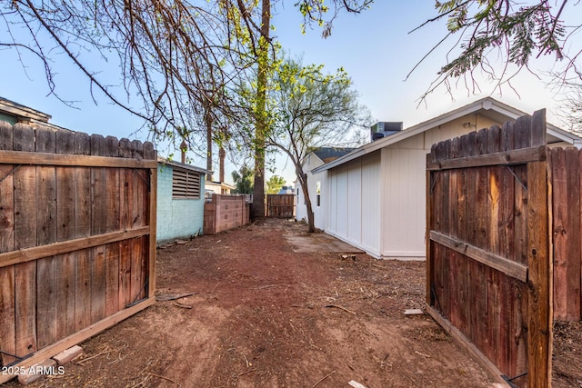 view of yard with central air condition unit and fence