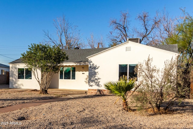 ranch-style house with stucco siding and a shingled roof