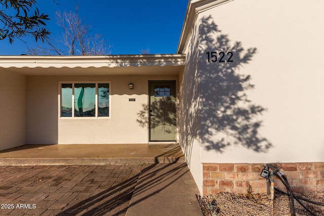 view of exterior entry with stucco siding