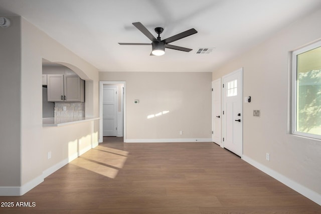 unfurnished living room with baseboards and wood finished floors