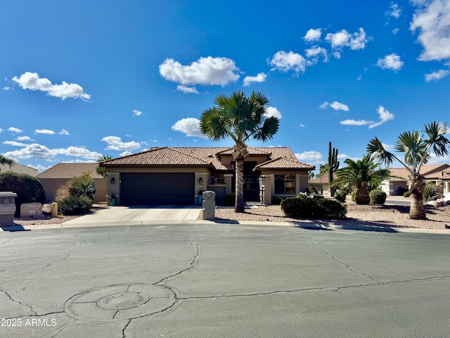 view of front of house with a garage, concrete driveway, a tile roof, and stucco siding