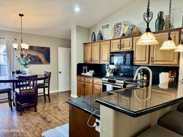 kitchen featuring black microwave, visible vents, backsplash, dark wood finished floors, and stainless steel range with gas stovetop