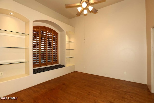 wine cellar with wood finished floors, a ceiling fan, and built in shelves
