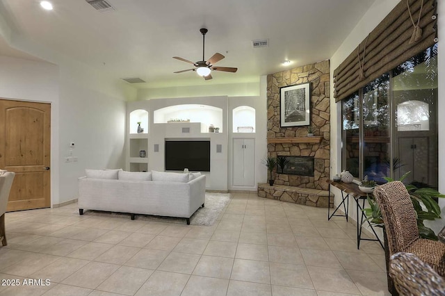 living area featuring light tile patterned flooring, a ceiling fan, and visible vents