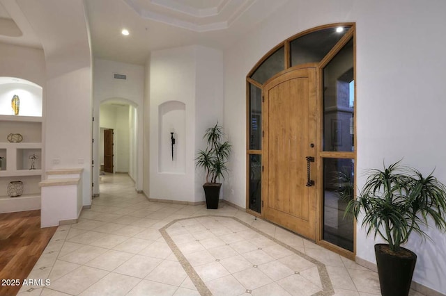 foyer entrance with arched walkways, visible vents, recessed lighting, light tile patterned flooring, and baseboards