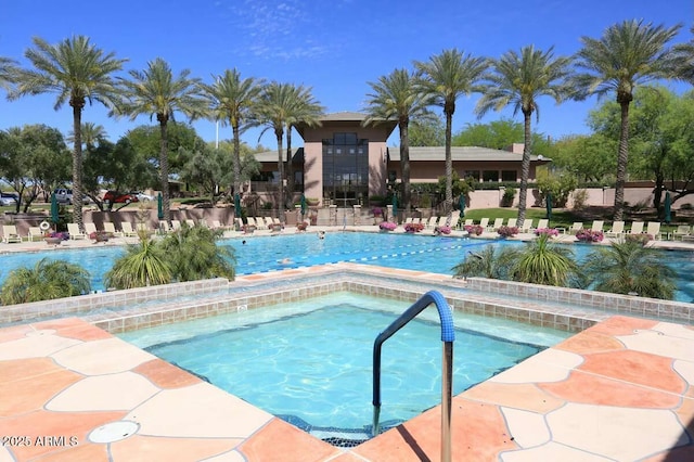pool featuring fence, a patio, and a hot tub
