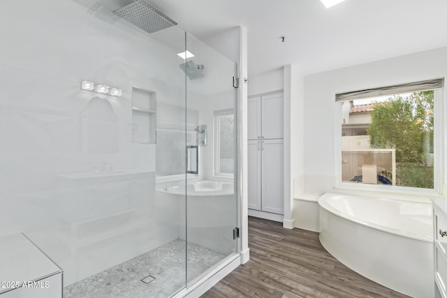 bathroom featuring wood-type flooring and plus walk in shower