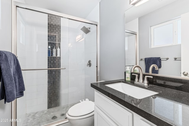 bathroom featuring vanity, an enclosed shower, and toilet