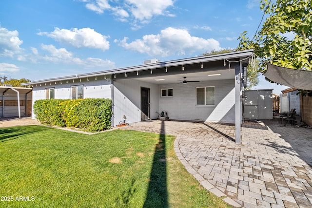 back of house featuring a yard, a shed, ceiling fan, and a patio area