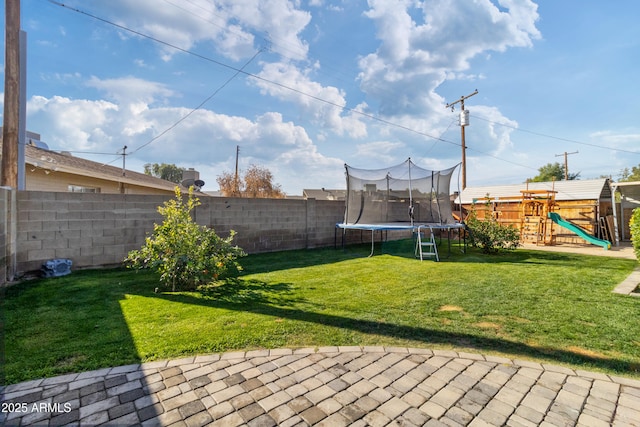 view of yard with a playground and a trampoline