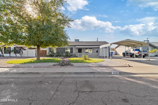 view of front of house featuring a carport, a garage, and a front lawn