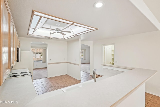 kitchen featuring ceiling fan, plenty of natural light, sink, and light tile patterned floors