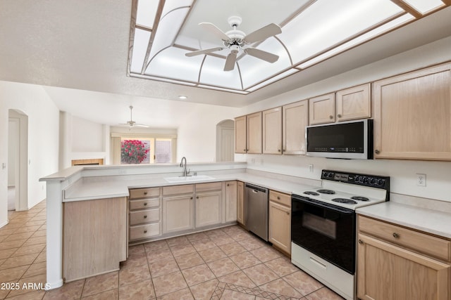 kitchen with light brown cabinets, sink, ceiling fan, appliances with stainless steel finishes, and kitchen peninsula