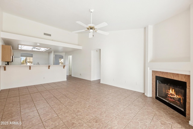 unfurnished living room featuring ceiling fan and a fireplace