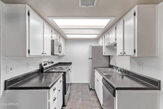 kitchen with white cabinets, sink, appliances with stainless steel finishes, and a textured ceiling