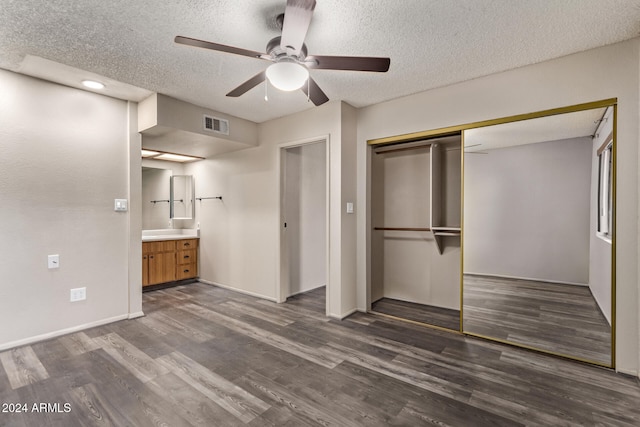 unfurnished bedroom featuring a textured ceiling, a closet, ceiling fan, and dark wood-type flooring