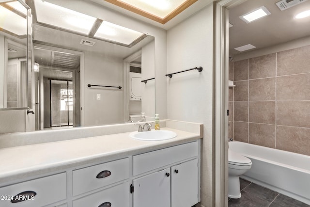 full bathroom featuring tile patterned flooring, vanity, toilet, and tiled shower / bath