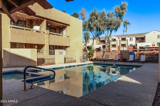 view of swimming pool featuring a hot tub