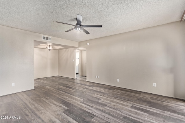 empty room with ceiling fan, dark hardwood / wood-style flooring, and a textured ceiling