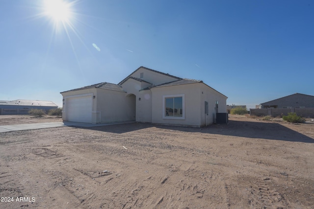 view of front of home with a garage and central air condition unit