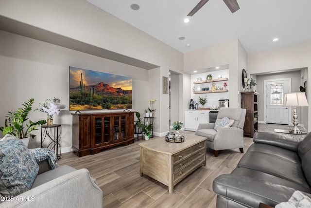 living area featuring baseboards, ceiling fan, wood finish floors, a bar, and recessed lighting