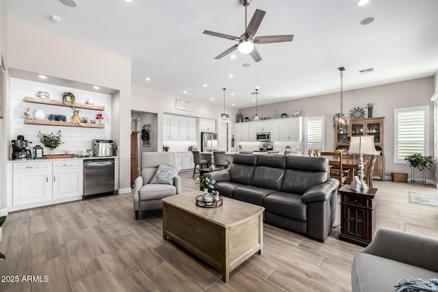 living area featuring light wood-style floors, recessed lighting, visible vents, and baseboards