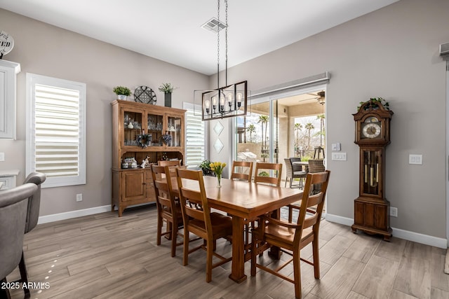 dining room featuring light wood finished floors, baseboards, and visible vents