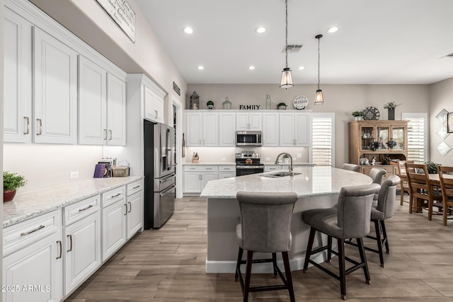 kitchen featuring recessed lighting, visible vents, appliances with stainless steel finishes, white cabinetry, and a sink