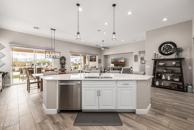 kitchen with visible vents, dishwasher, an island with sink, white cabinetry, and a sink