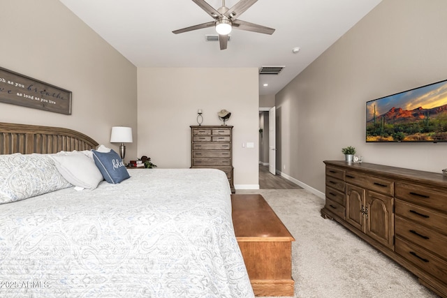 bedroom with light carpet, ceiling fan, visible vents, and baseboards