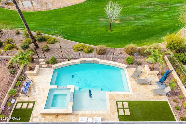 view of swimming pool with a fenced backyard, a pool with connected hot tub, and a yard