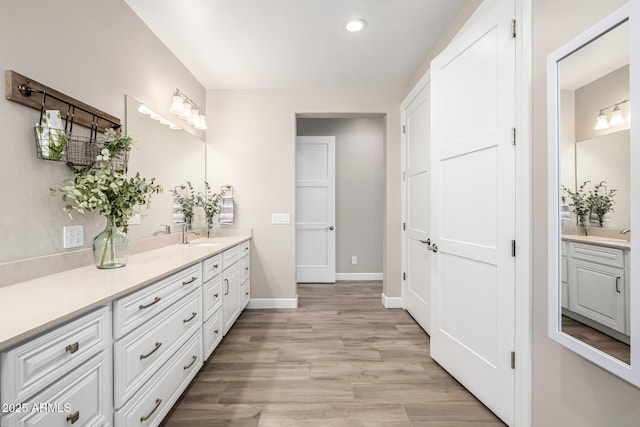 full bathroom with recessed lighting, wood finished floors, vanity, and baseboards