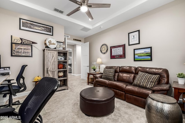 carpeted living area featuring baseboards, ceiling fan, visible vents, and a tray ceiling