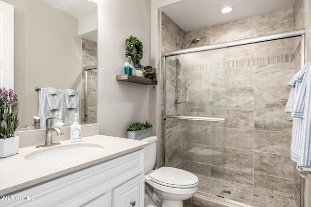 full bathroom featuring toilet, a stall shower, and vanity