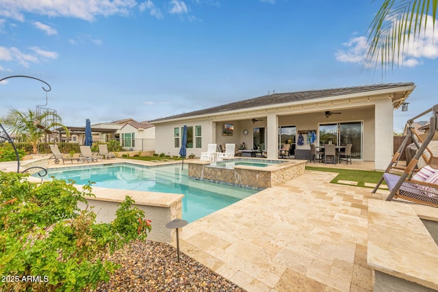 view of pool with a pool with connected hot tub, a patio area, fence, and ceiling fan