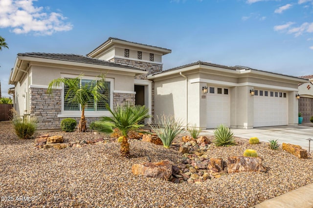 prairie-style house featuring stone siding, driveway, an attached garage, and stucco siding