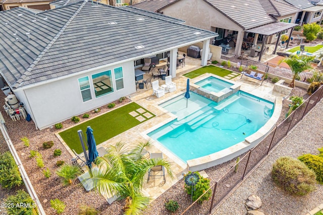 view of swimming pool featuring a yard, a patio area, a fenced backyard, and a pool with connected hot tub