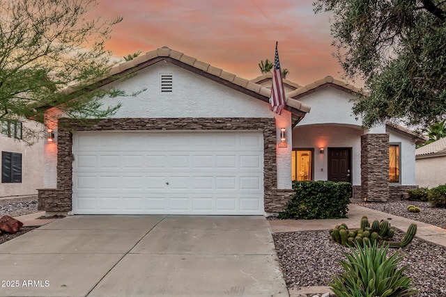 2108 E Patrick Ln, Phoenix, AZ 85024 - view of front of home featuring stone siding, driveway, stucco siding, and an attached garage