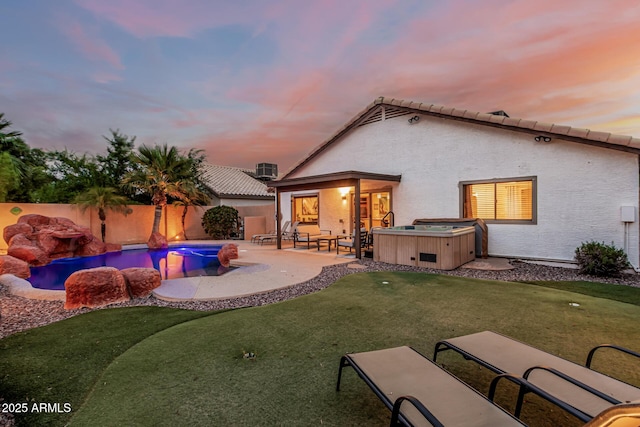 2108 E Patrick Ln, Phoenix, AZ 85024 - back of property at dusk with a hot tub, a fenced backyard, a patio, a putting area, and stucco siding
