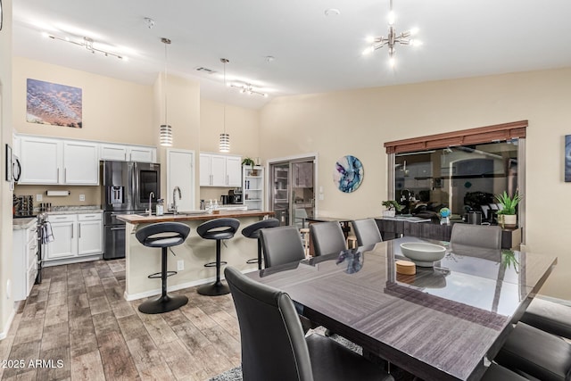 2108 E Patrick Ln, Phoenix, AZ 85024 - dining space featuring rail lighting, a high ceiling, and light wood-style flooring