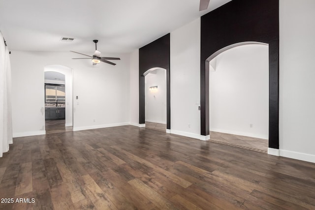 46065 W Meadows Ln, Maricopa, AZ 85139 - unfurnished living room featuring ceiling fan, dark wood-style floors, and arched walkways