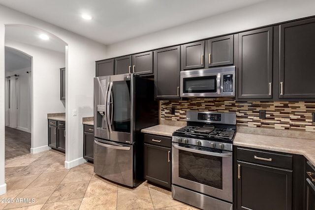 46065 W Meadows Ln, Maricopa, AZ 85139 - kitchen with appliances with stainless steel finishes, arched walkways, decorative backsplash, light countertops, and recessed lighting