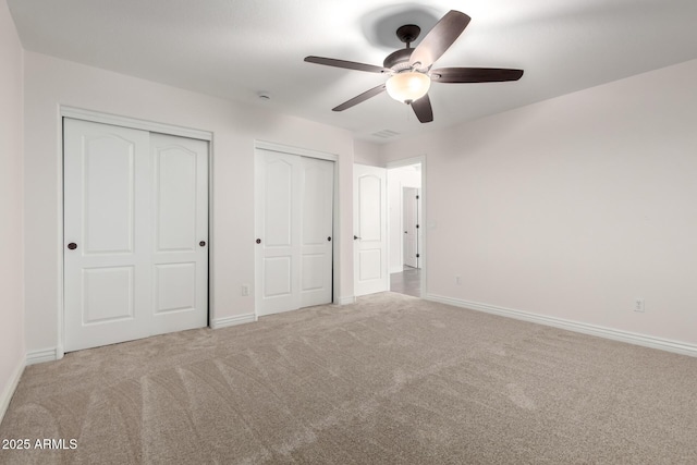 46065 W Meadows Ln, Maricopa, AZ 85139 - unfurnished bedroom featuring multiple closets, carpet, and a ceiling fan