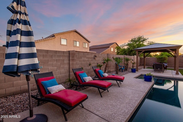 46065 W Meadows Ln, Maricopa, AZ 85139 - patio terrace at dusk with a gazebo, a patio, and a fenced backyard