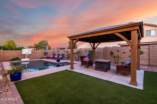 46065 W Meadows Ln, Maricopa, AZ 85139 - yard at dusk featuring a gazebo, a patio, and a fenced backyard