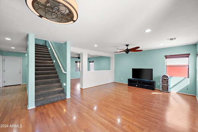 unfurnished living room with stairs, recessed lighting, visible vents, and wood finished floors