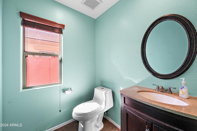 bathroom featuring toilet, vanity, visible vents, baseboards, and tile patterned floors