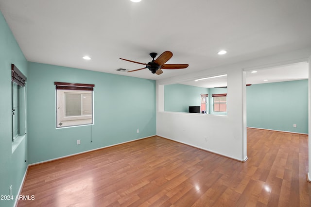 empty room with light wood-style floors, recessed lighting, visible vents, and a ceiling fan