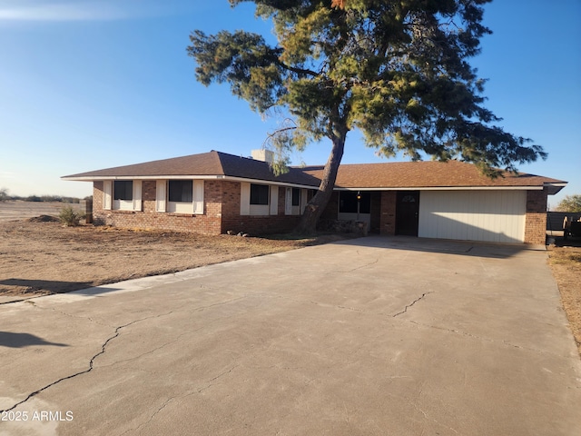 ranch-style home featuring concrete driveway and brick siding